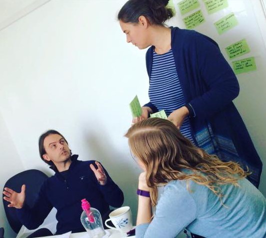 Image of a man in discussion with two women. 
