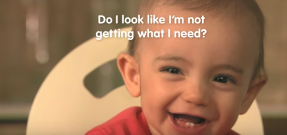 Image of a smiling baby with white text written over it saying:"Do I look like I'm not getting what I need?"