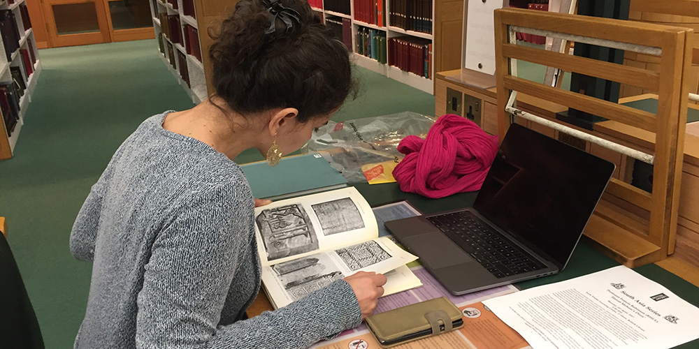 Picture of a woman researching a book inside the British Library.